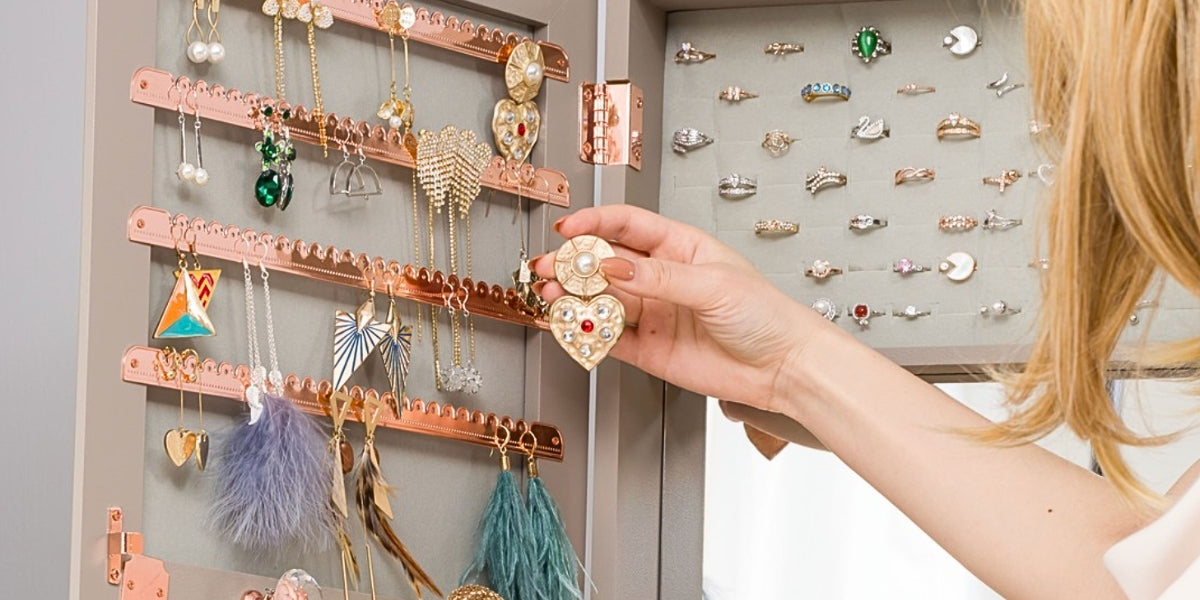 A woman choosing her earrings from a Standing Jewelry Armoire