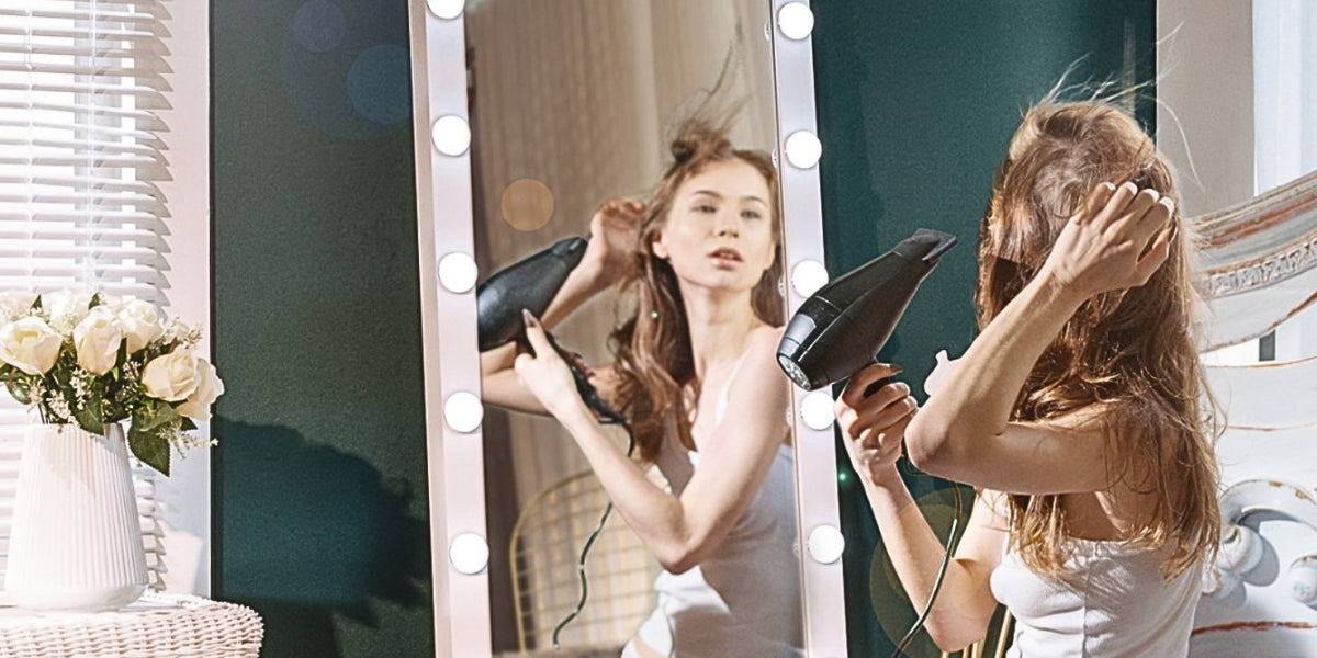 A woman fixing her hair in front of LUXFURNI Full-length Mirror with lights