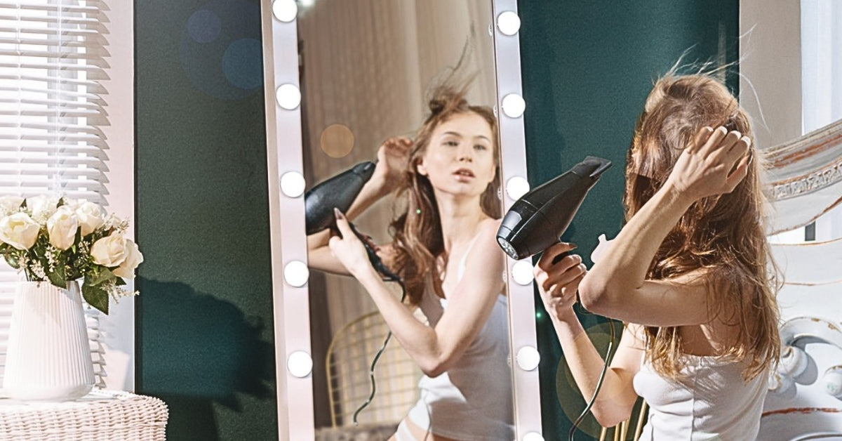 A woman fixing her hair in front of LUXFURNI Full-length Mirror with lights